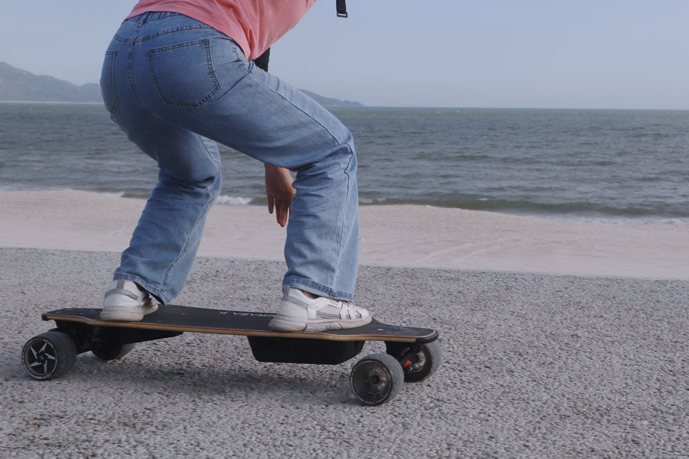 riding veymax e skateboard in beach